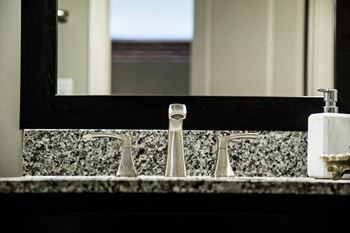 a bathroom sink with a faucet and a mirror at The Foundry, South Bend